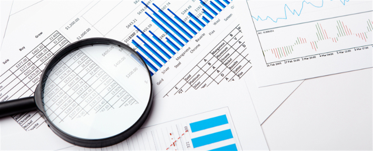 Photo of a magnifying glass over a series of charts